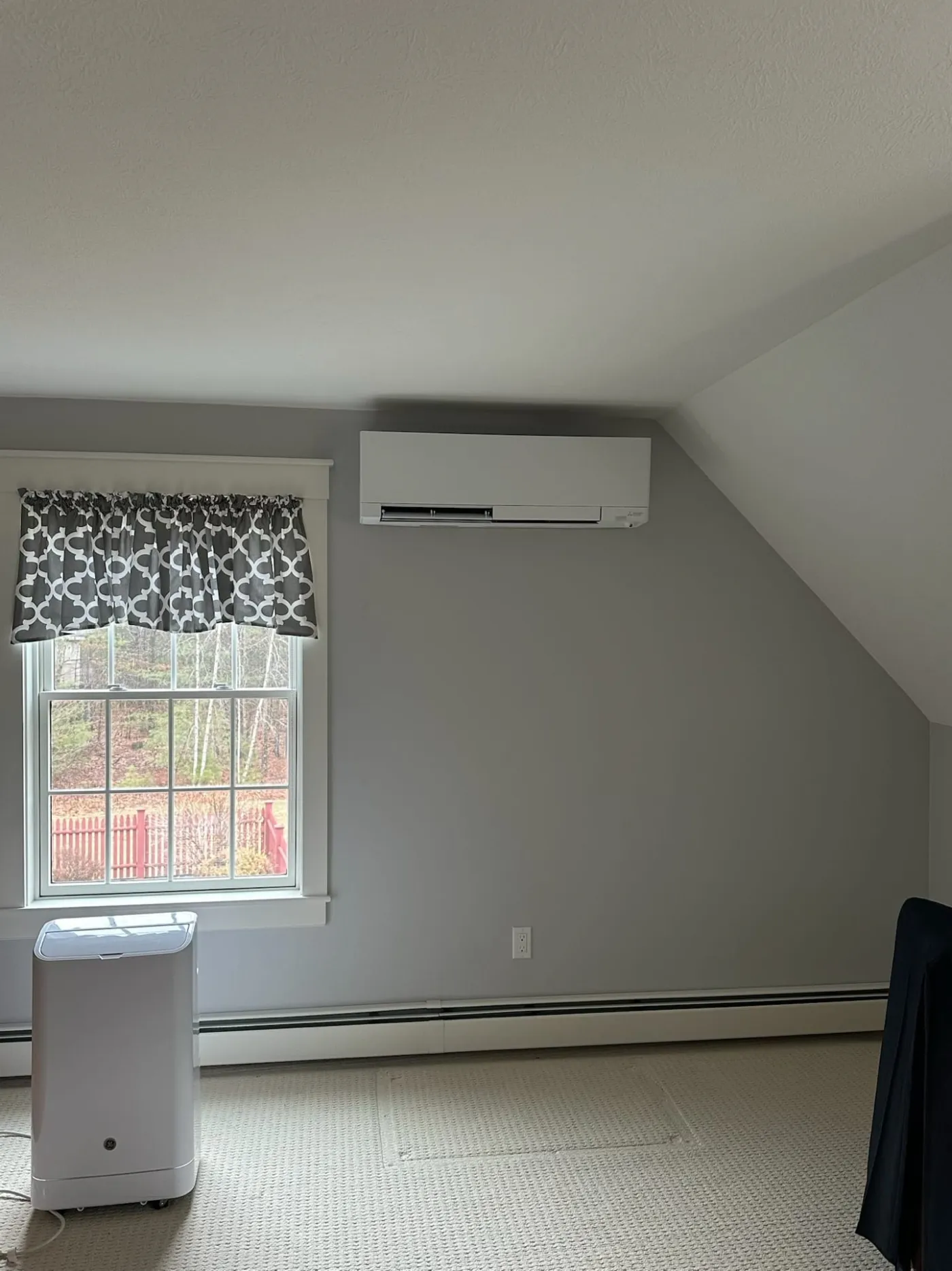 Mini-split indoor unit installed in a bedroom with a vaulted ceiling