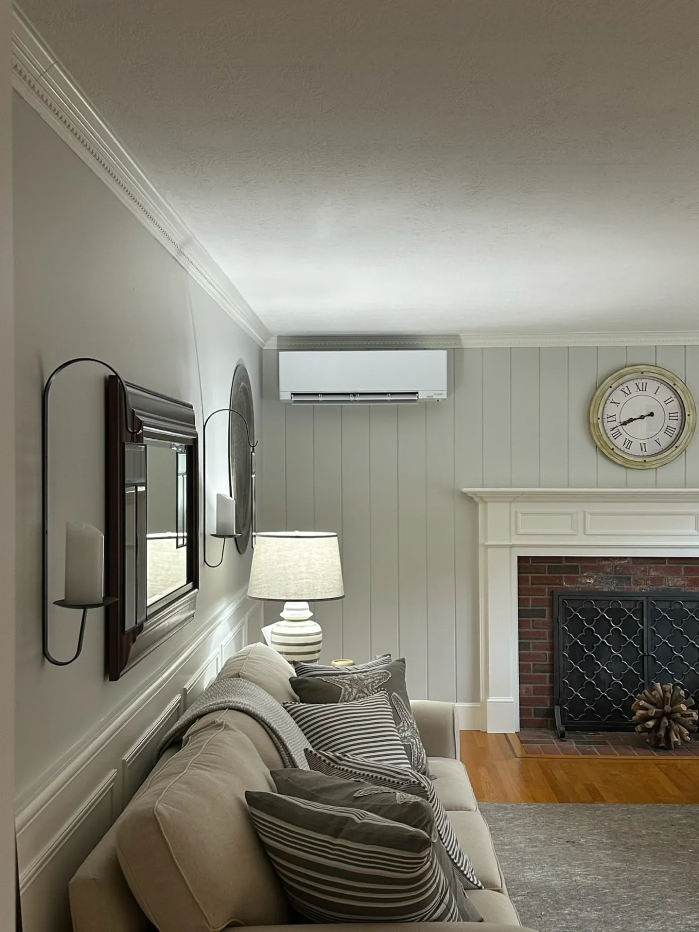 Indoor mini-split unit mounted in a living room with shiplap walls