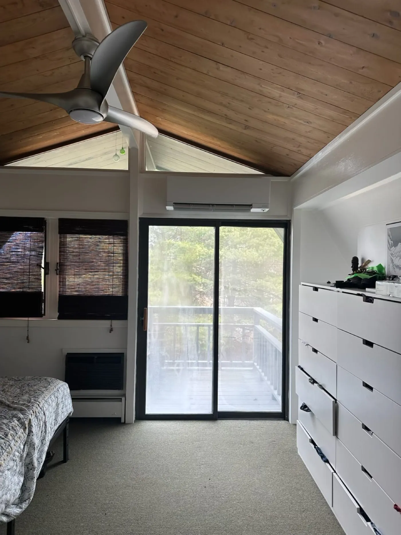 Ductless indoor unit installed near a large window in a wood-paneled sunroom