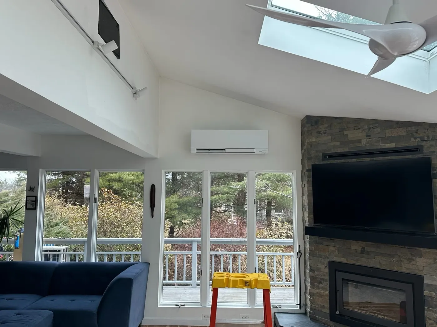 Ductless mini-split indoor unit installed in a vaulted living room with skylights