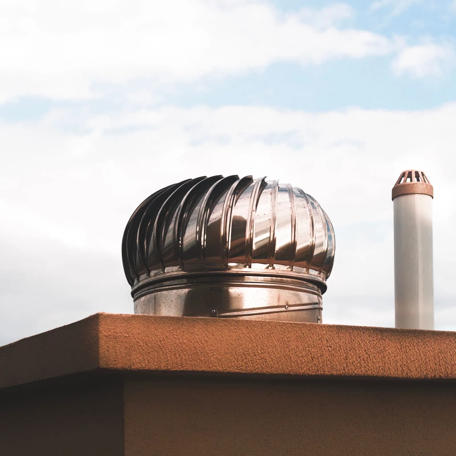 Roof-mounted ventilator cap against a clear sky